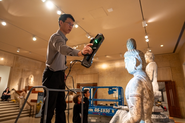 Professor Chen Qiang of Xi'an Jiaotong University conducting 3d scanning of a seated Buddha sculpture, at the Art Institute of Chicago